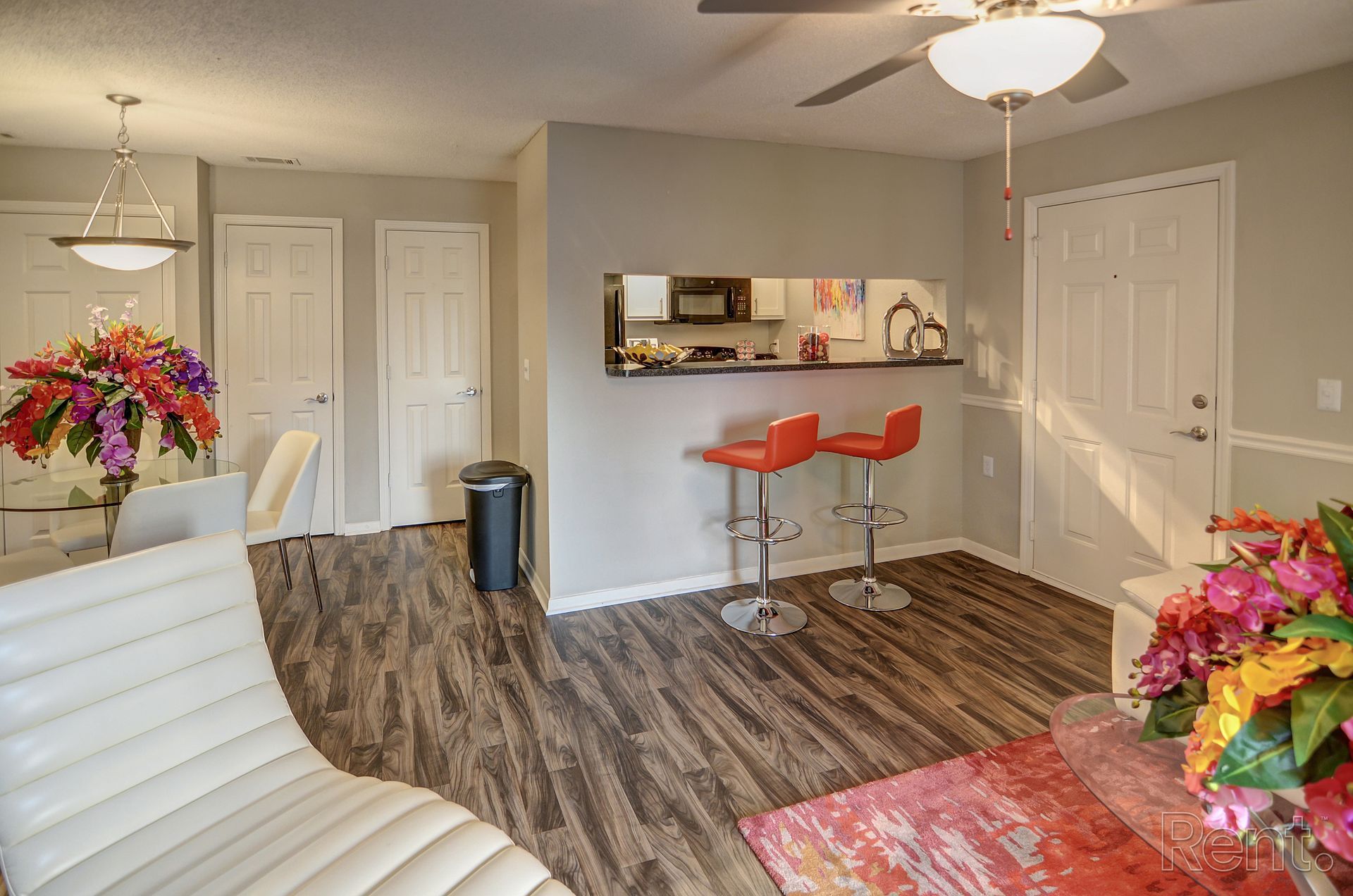 A living room with hardwood floors and a ceiling fan.