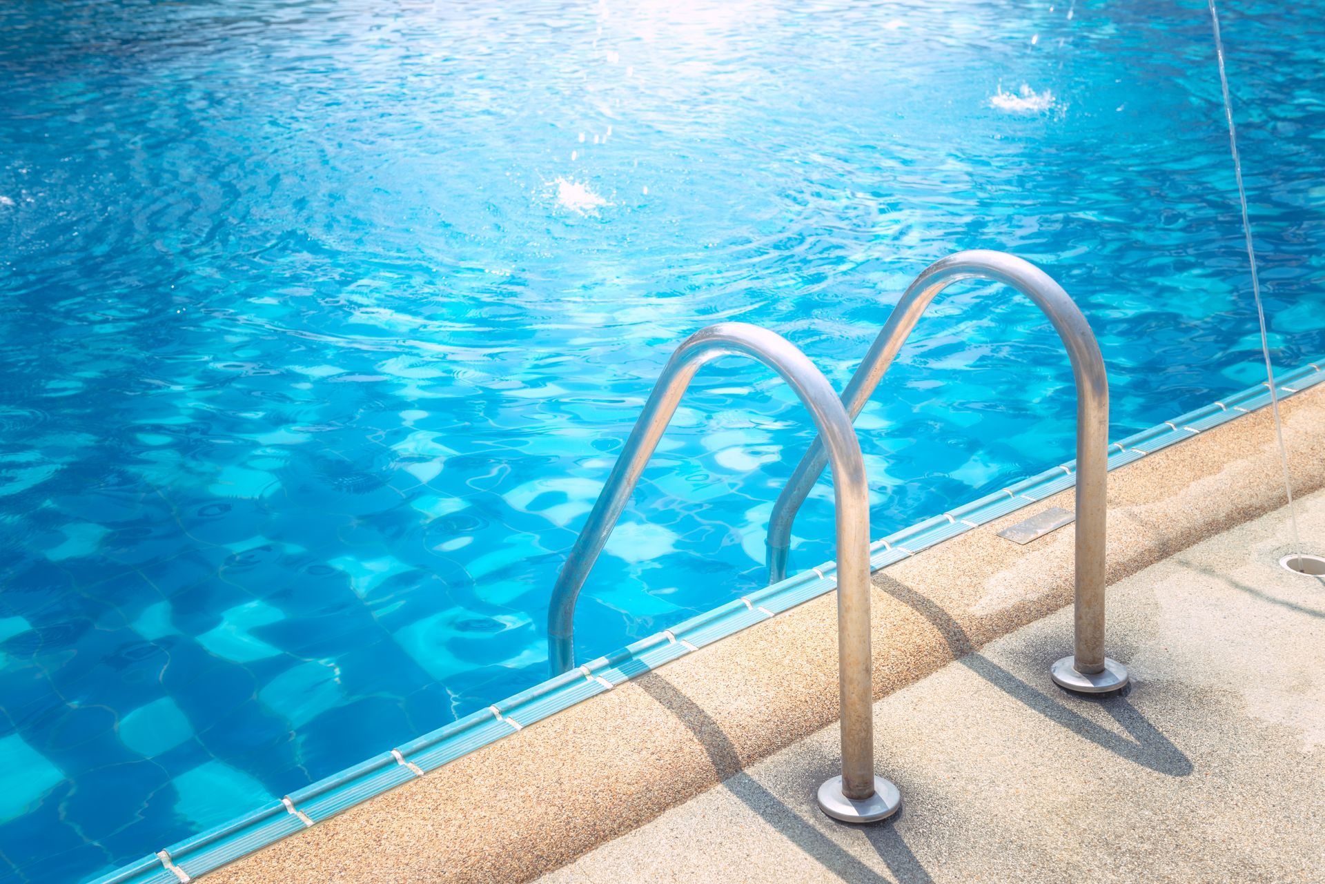 Grab bars ladder in the blue swimming pool.