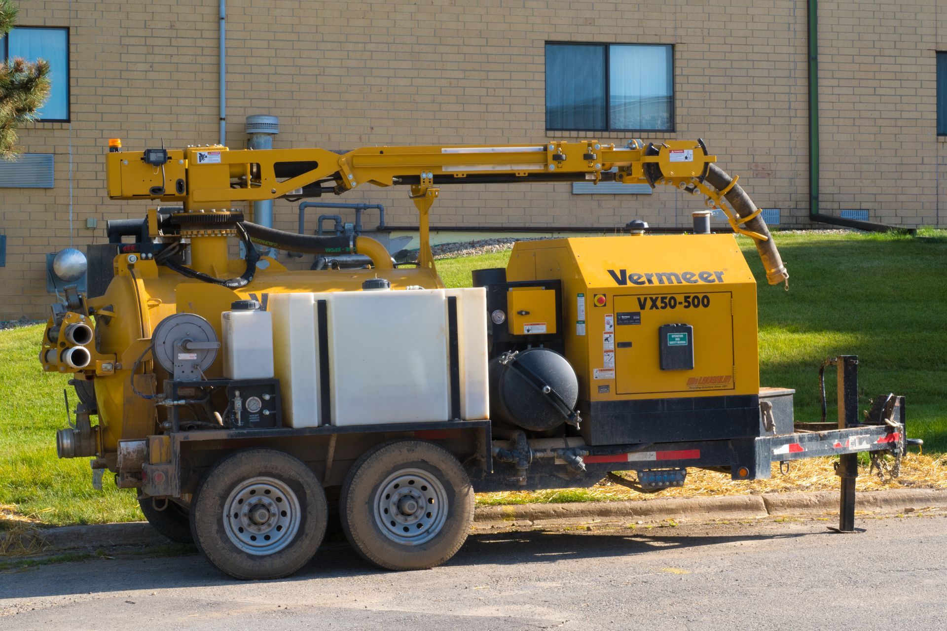 Yellow Vermeer VS12-300 vacuum excavator trailer on grass.