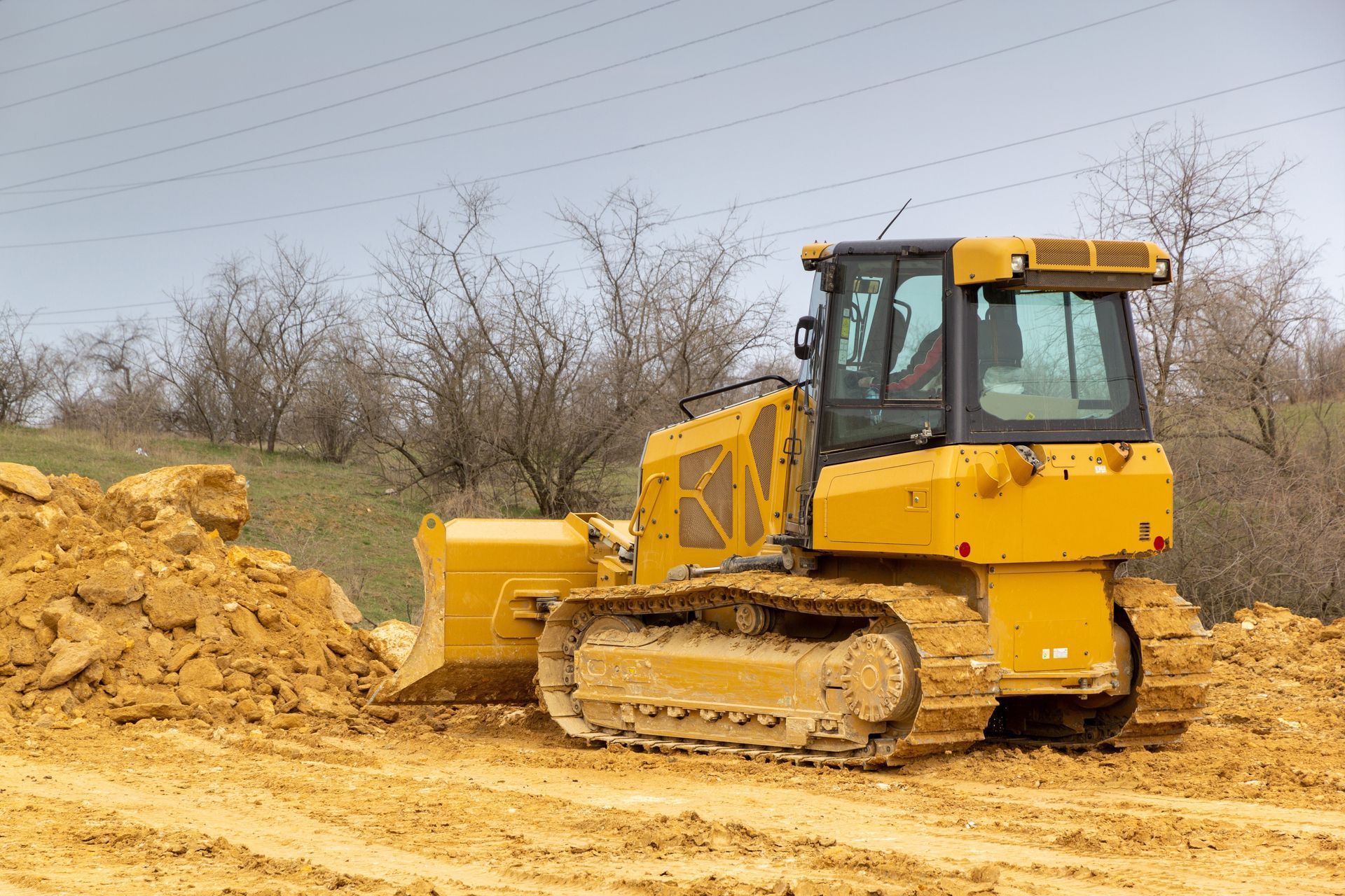 Yellow bulldozer pushing dirt on a construction site.