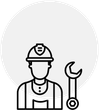 A man wearing a hard hat and overalls is holding a wrench.