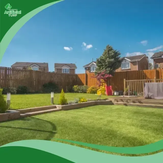 Henderson Artificial Turf - A beautifully manicured artificial turf lawn in a backyard with houses and a wooden fence under a clear blue sky.