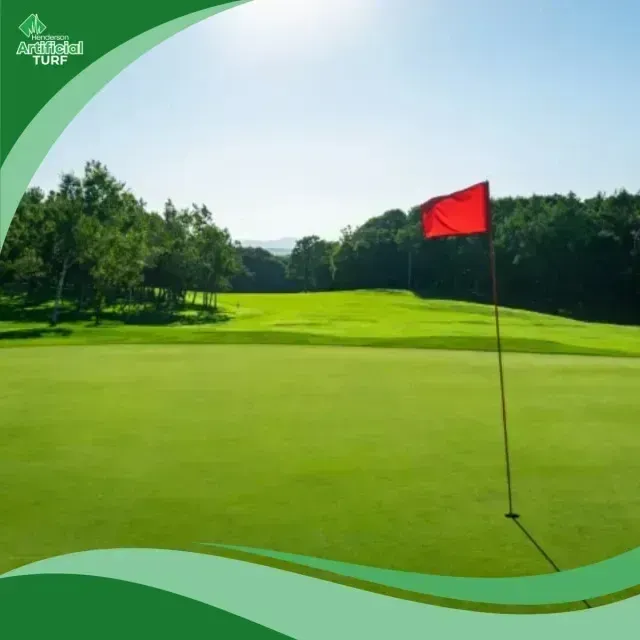 Henderson Artificial Turf - A bright red flag marks the golf hole on a lush green course under a clear blue sky.