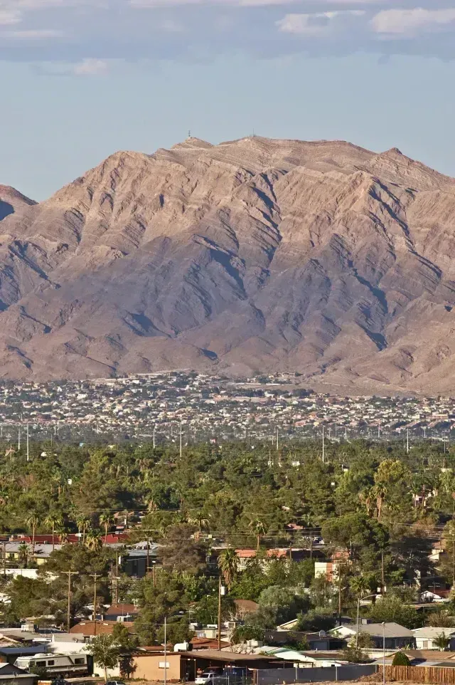 Henderson Artificial Turf -Expansive view of a city nestled at the base of a large, rugged mountain range.