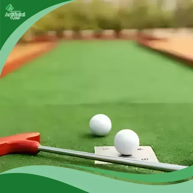 Henderson Artificial Turf is showcased in this image of a putting green with two white golf balls and a red putter, set against a smooth, vibrant synthetic grass surface.