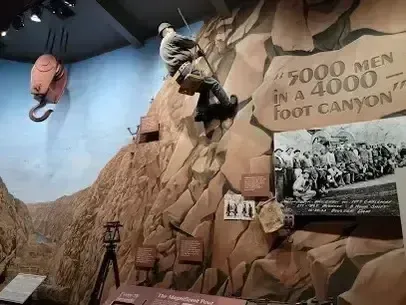 Henderson Artificial Turf -  mirrors the dedication captured in this image from the Boulder City-Hoover Dam Museum, showing a worker mannequin climbing a steep rock wall.