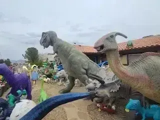Henderson Artificial Turf - A group of dinosaurs gathered outside, with a clear sky overhead and the ground beneath them.
