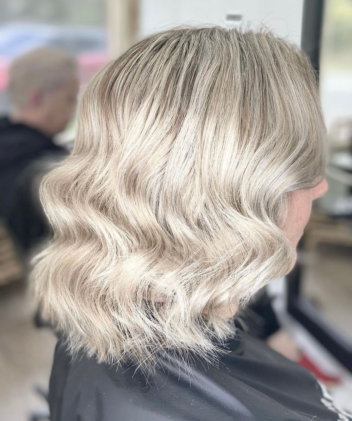 A woman with blonde hair is getting her hair cut in a salon — Hair Creations in Blackalls Park, NSW