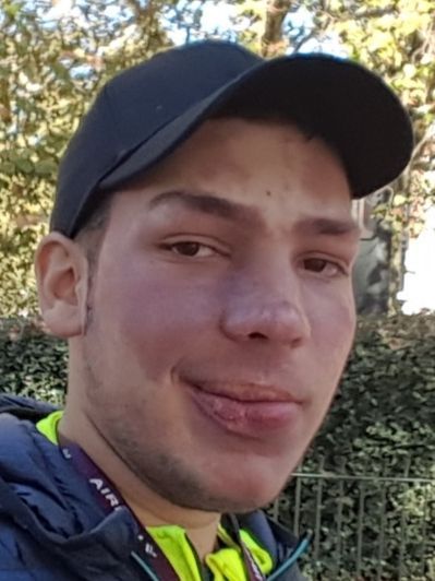 Un giovane con la sindrome di Sturge Weber che indossa un cappello nero 