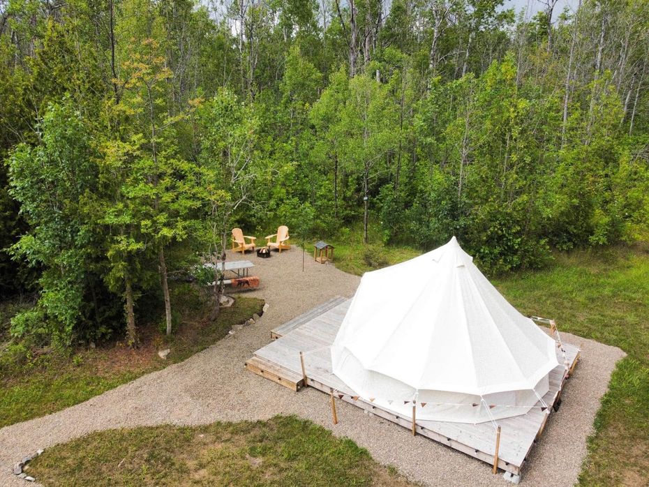 An aerial view of a tent in the middle of a forest.