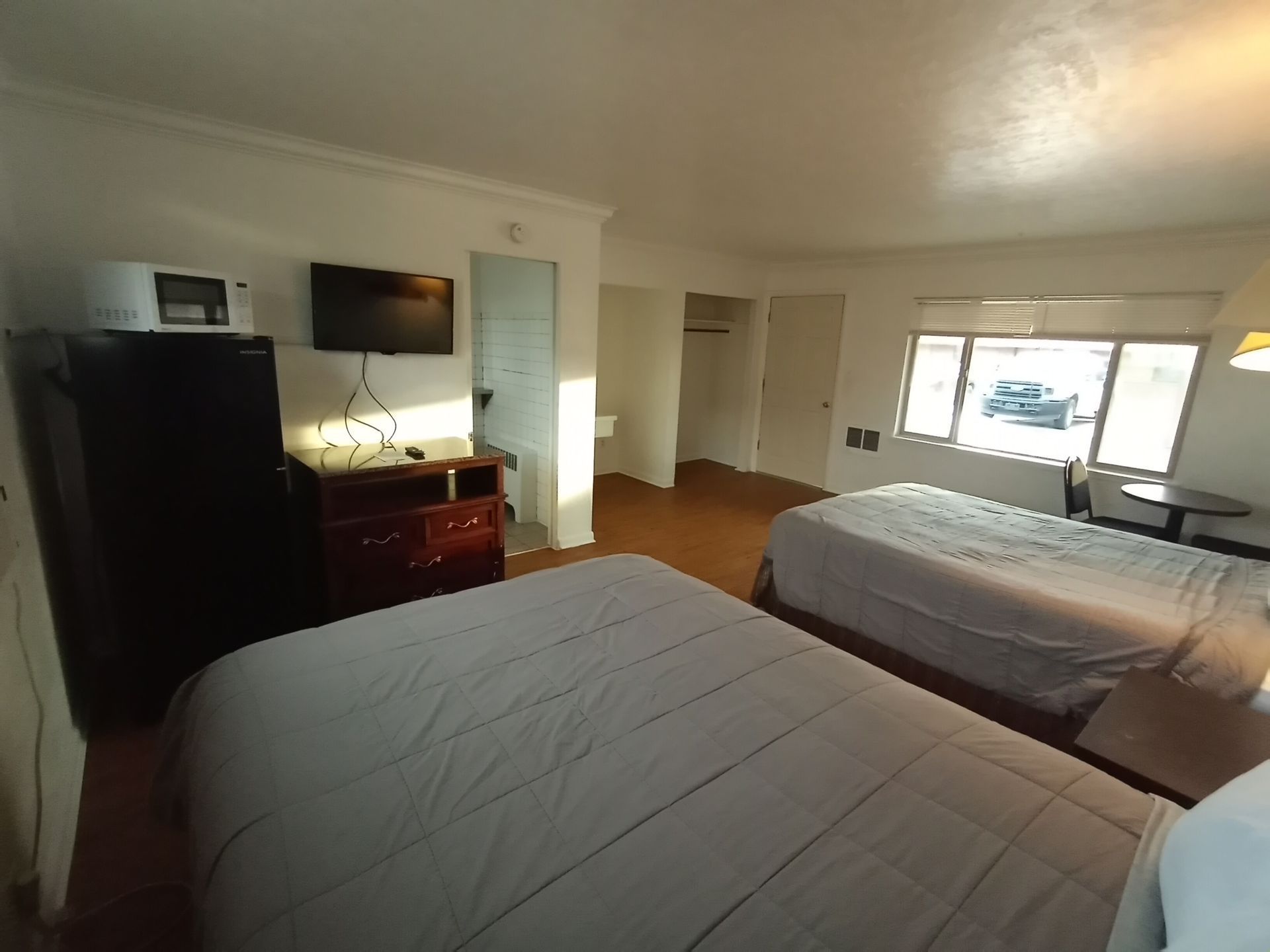 A hotel room with two beds and a lamp