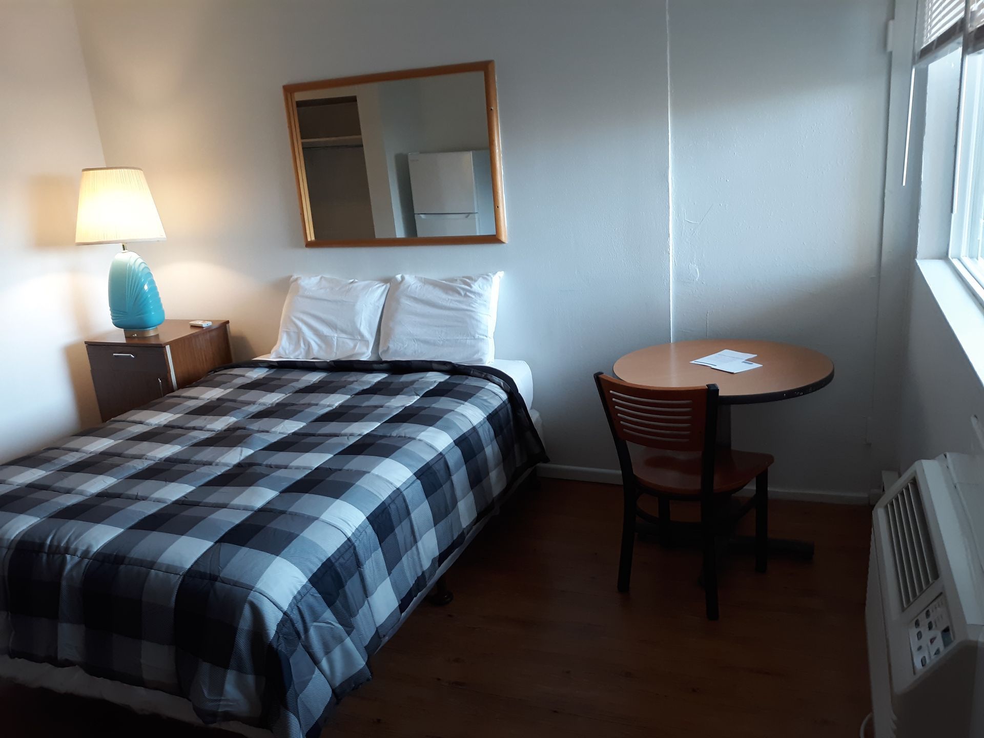 A hotel room with a king size bed and blue pillows.