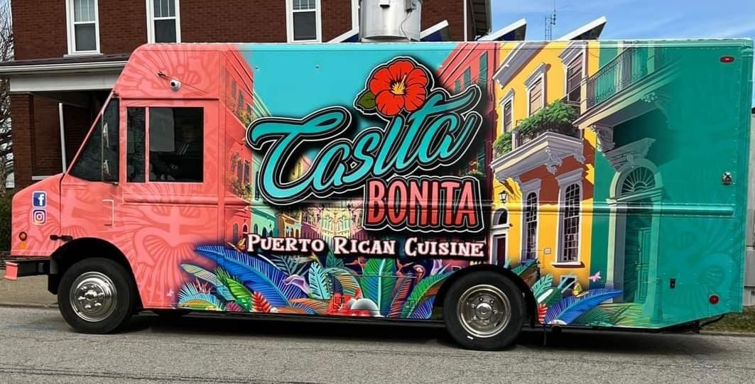 Casita Bonita food truck with colorful murals of Caribbean scenes, parked on a street.