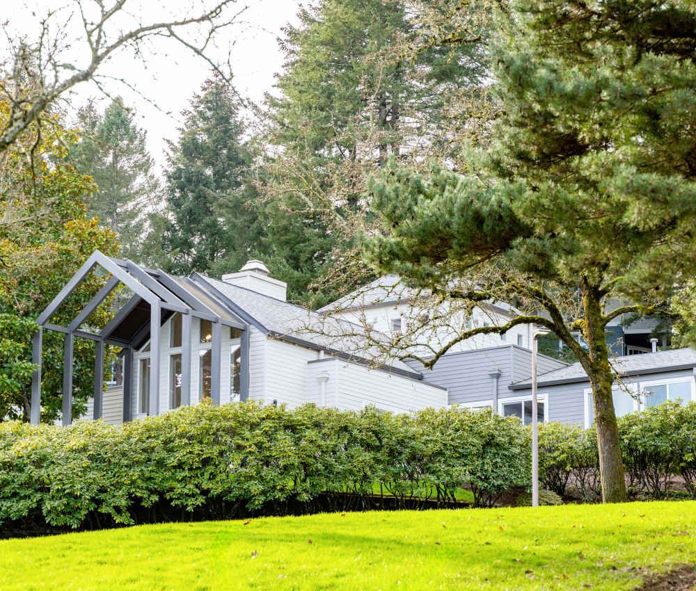 Exterior view of a modern apartment community with white buildings and lush landscaping.