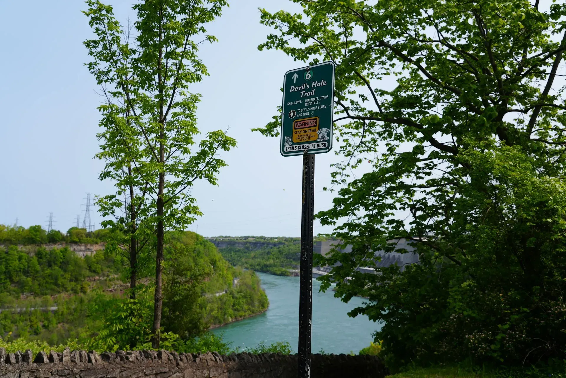 A green sign on a pole with a river in the background