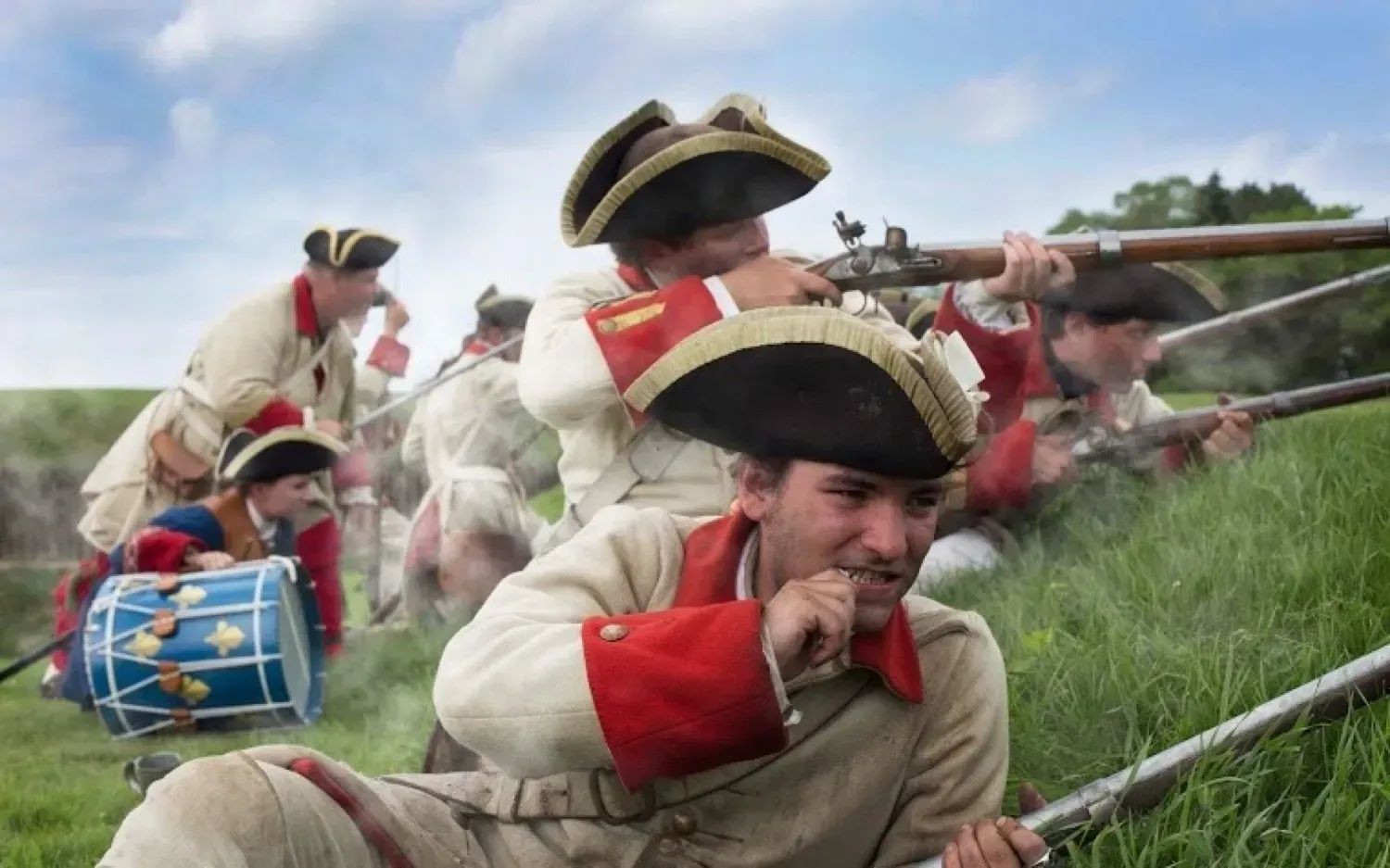 A group of soldiers are fighting in a field with a drum in the foreground.