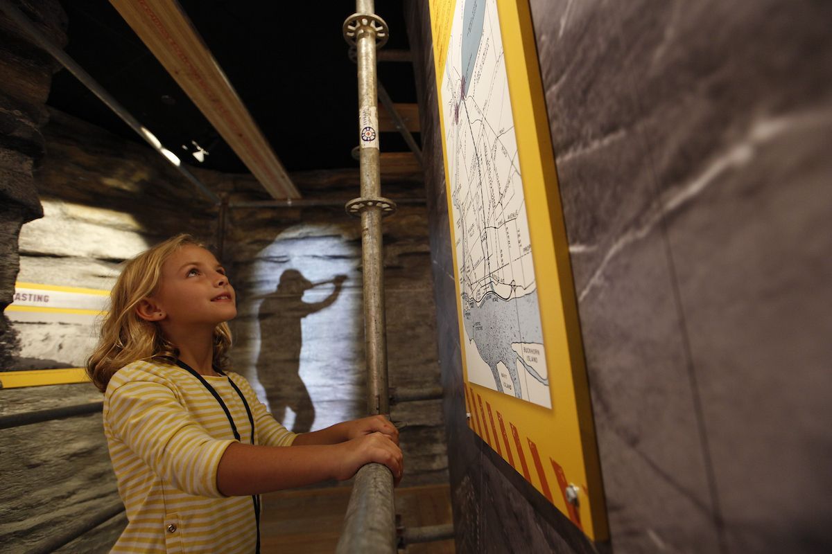 A little girl is looking at a map on a wall