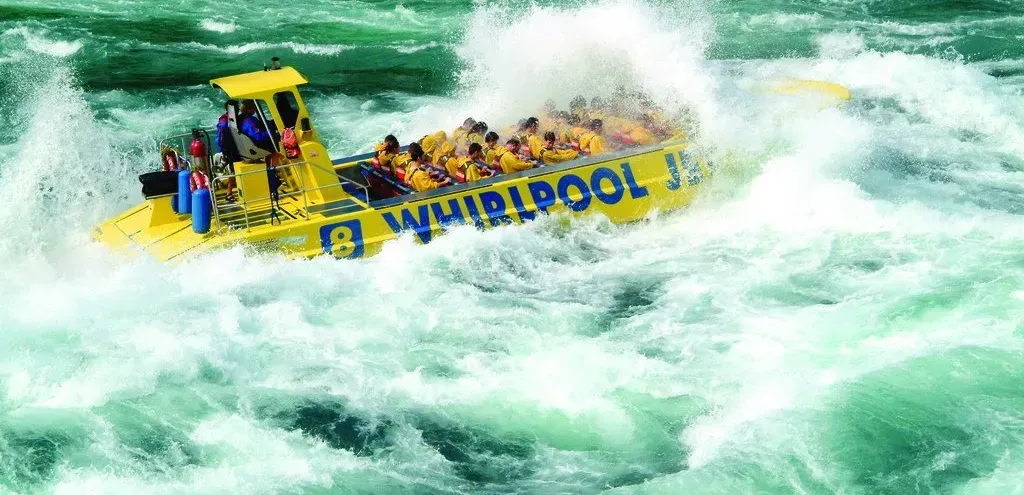 A group of people are riding a boat through a river.