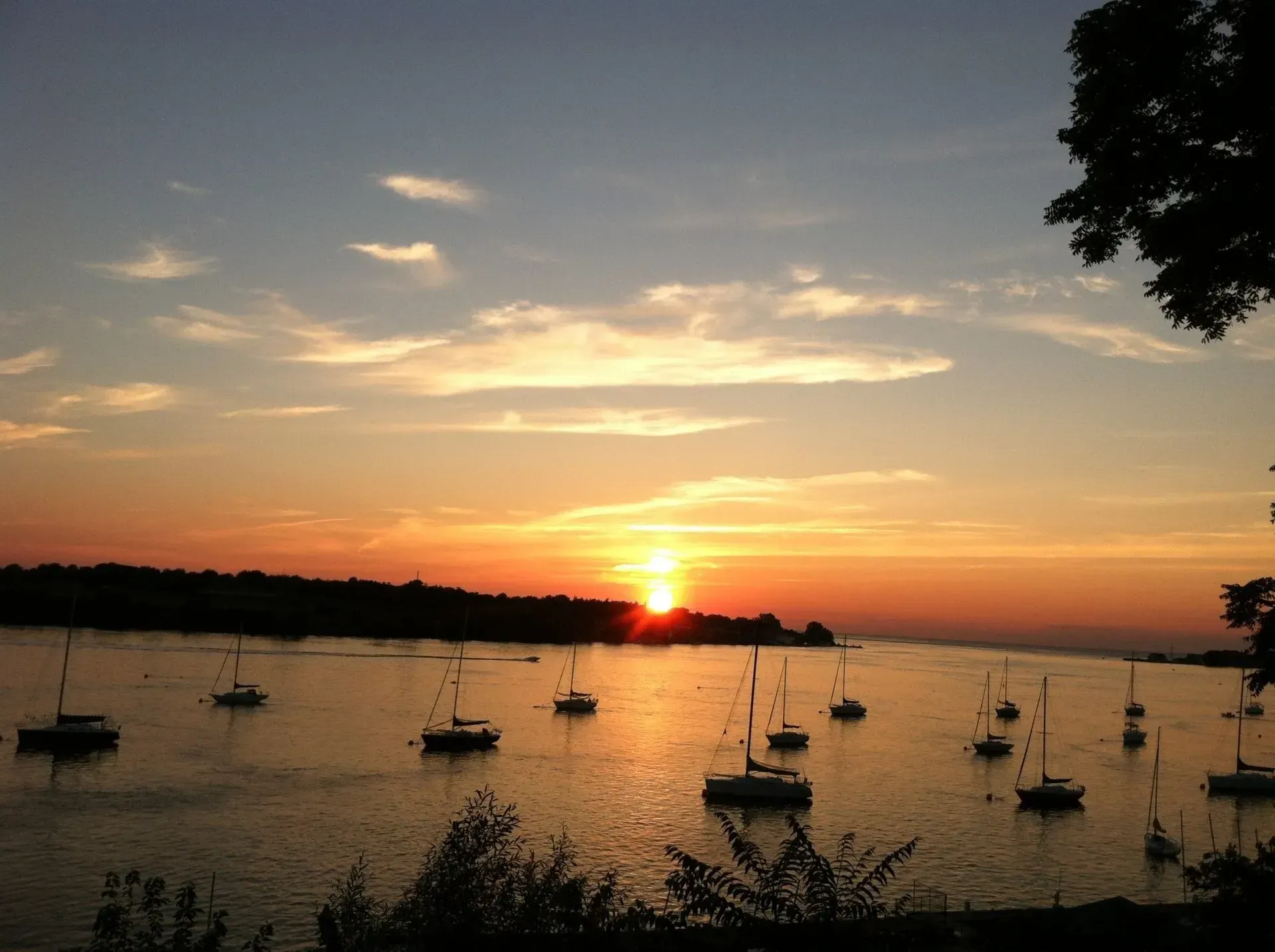 A sunset over a body of water with boats in it