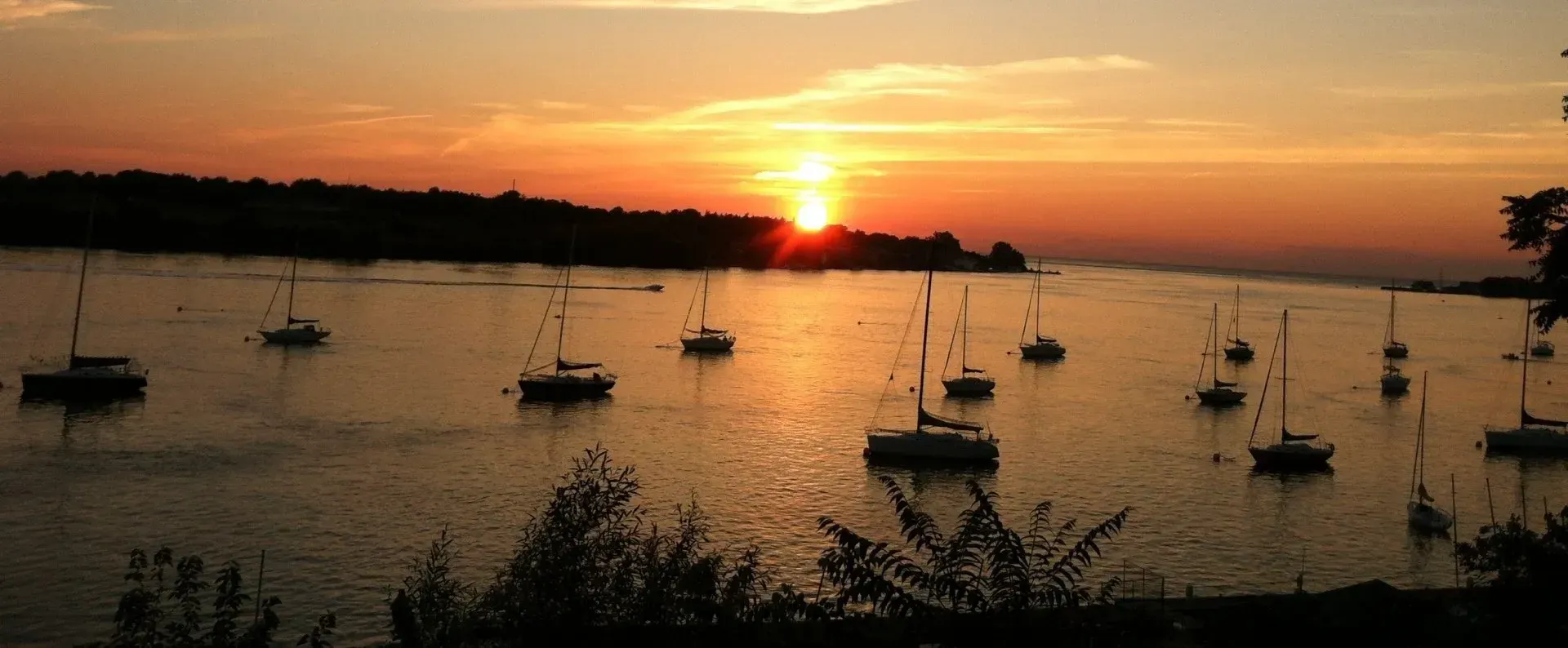 A sunset over a body of water with boats in it