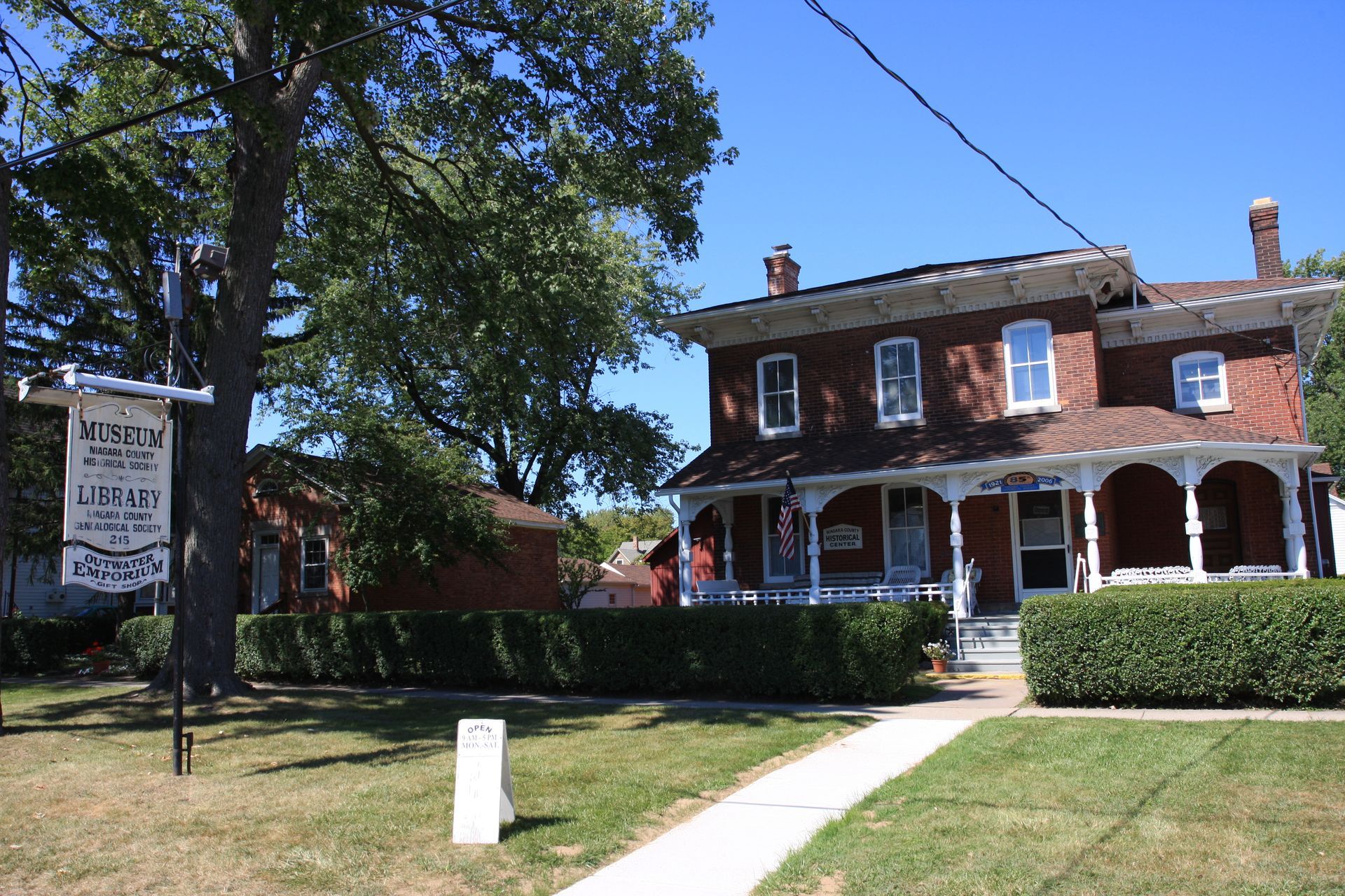 A brick house with a porch and a sign that says library