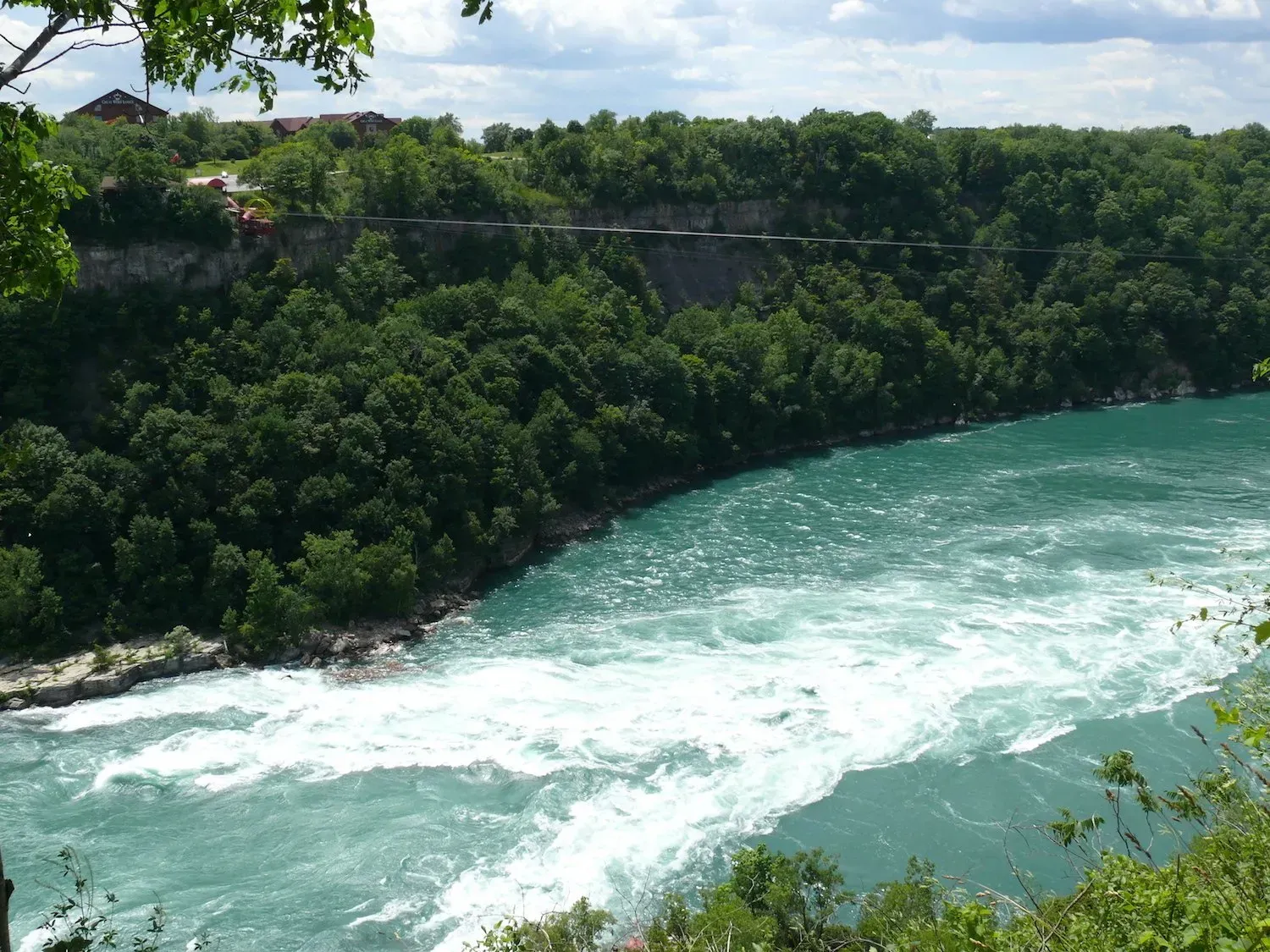 A large body of water surrounded by trees and cliffs