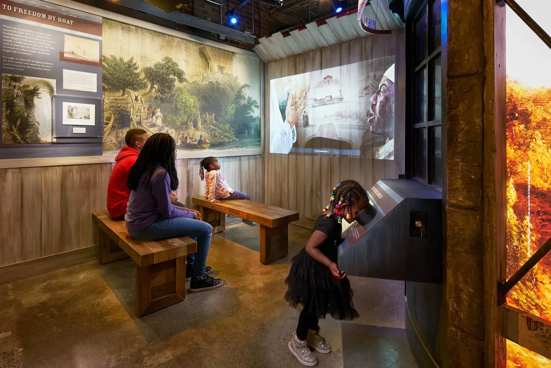 A group of people are sitting on benches in a room.