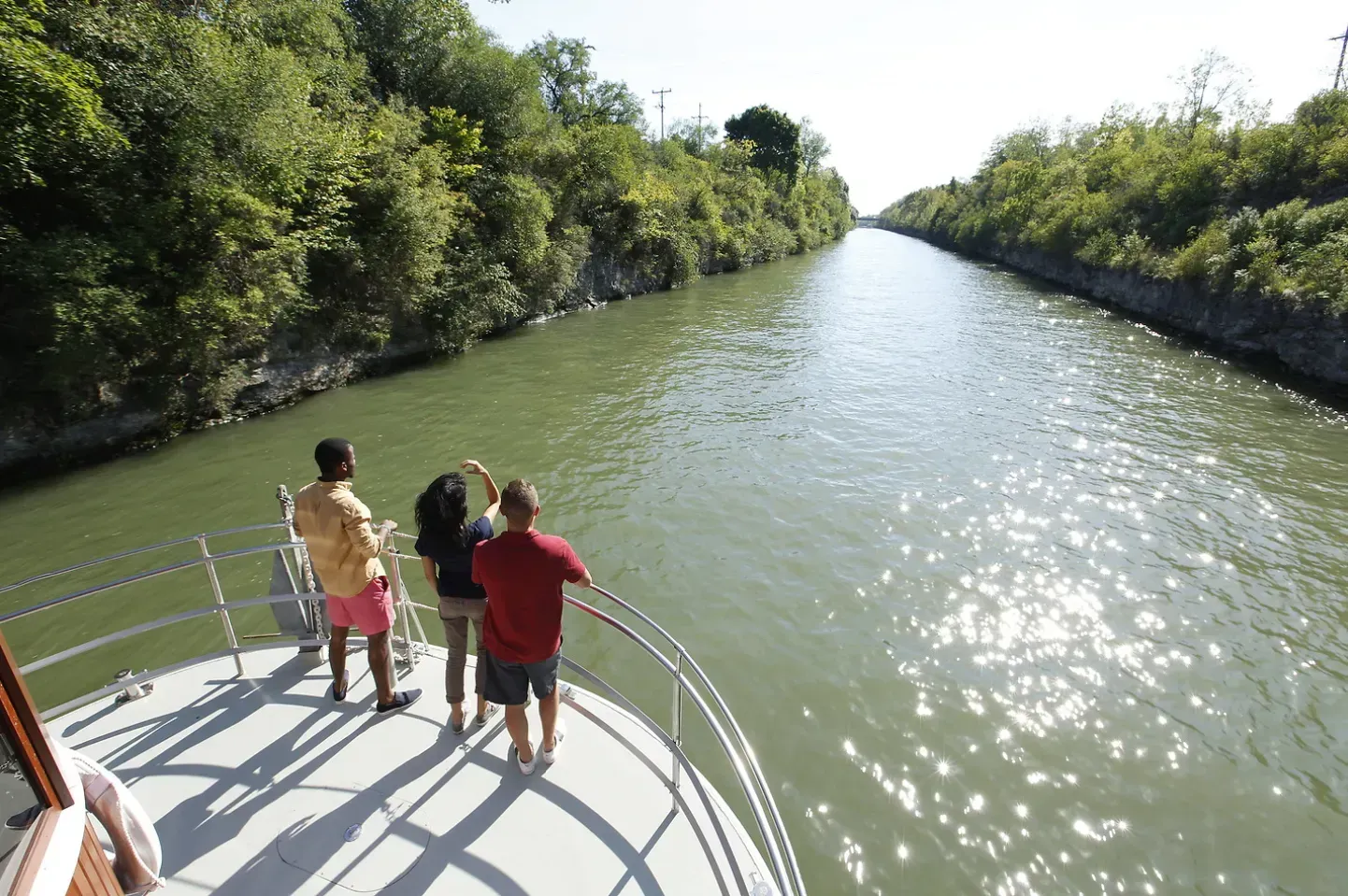 A group of people standing on a boat looking at a river