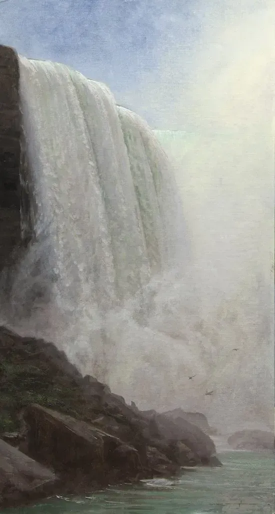 A waterfall is falling into a body of water.