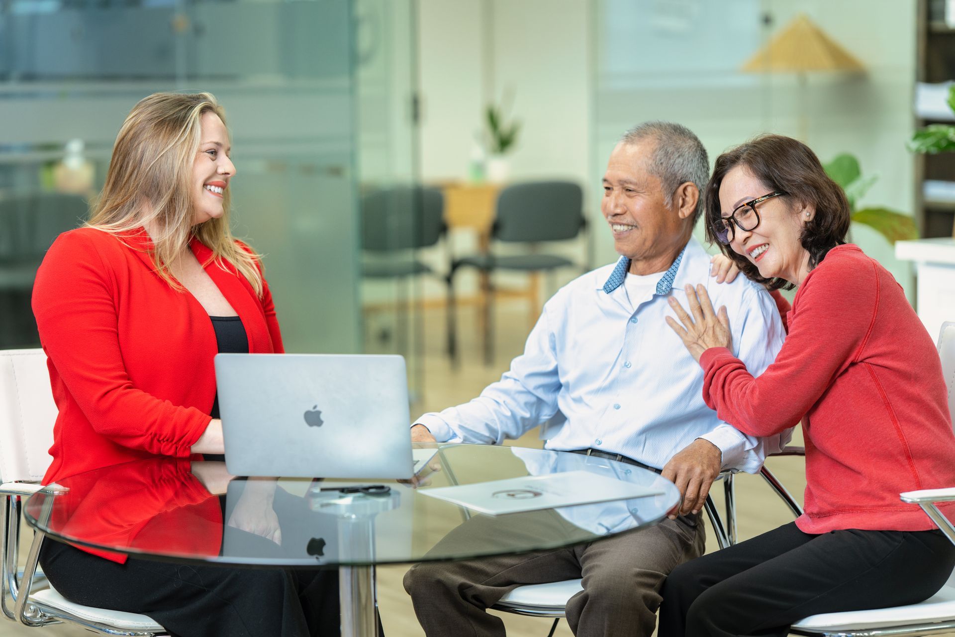 Family of three on a couch: adult, older woman wearing glasses, child smiling and hugging the woman.