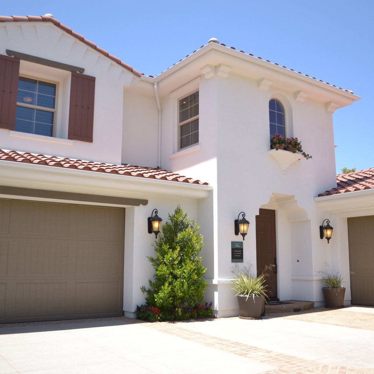 A white house with a brown garage door