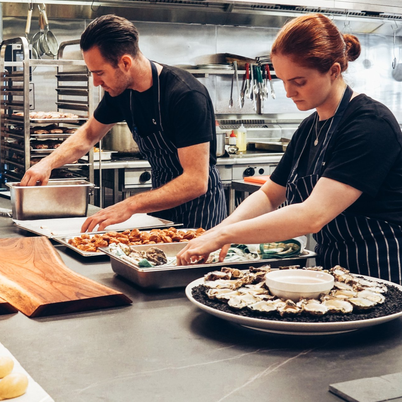 A man and a woman are preparing food in a kitchen