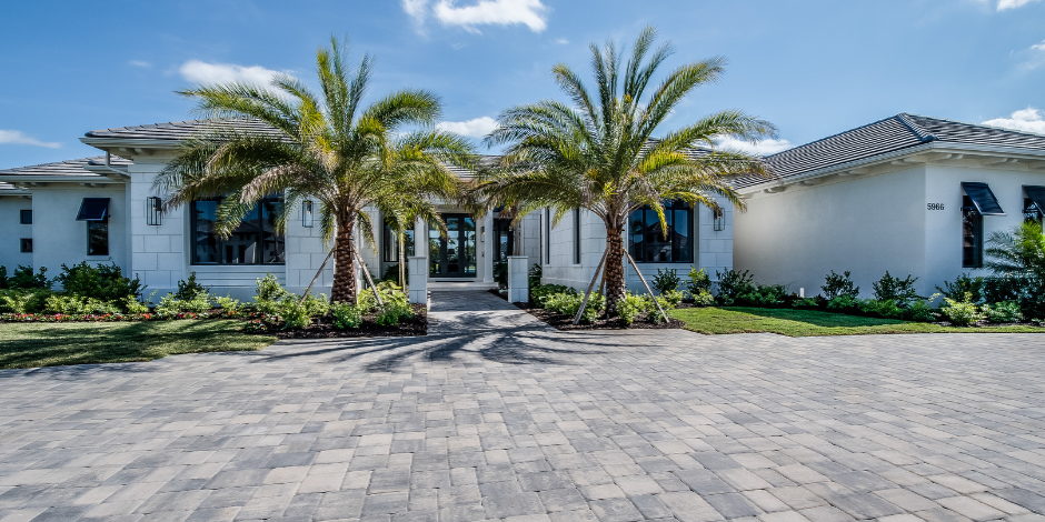 A large white house with palm trees in front of it.