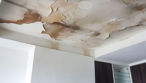 A ceiling with water stains on it in a room.