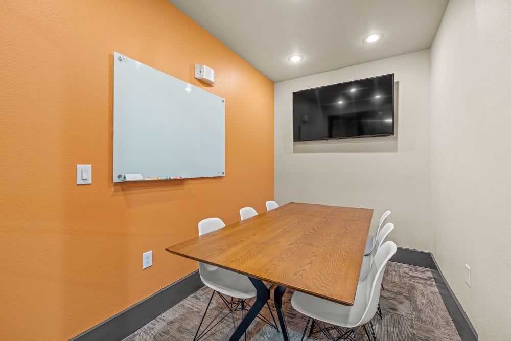 24-hour studyroom with a wooden table and chairs and a whiteboardat Regents West at 26th in Austin, TX, near UT Austin..