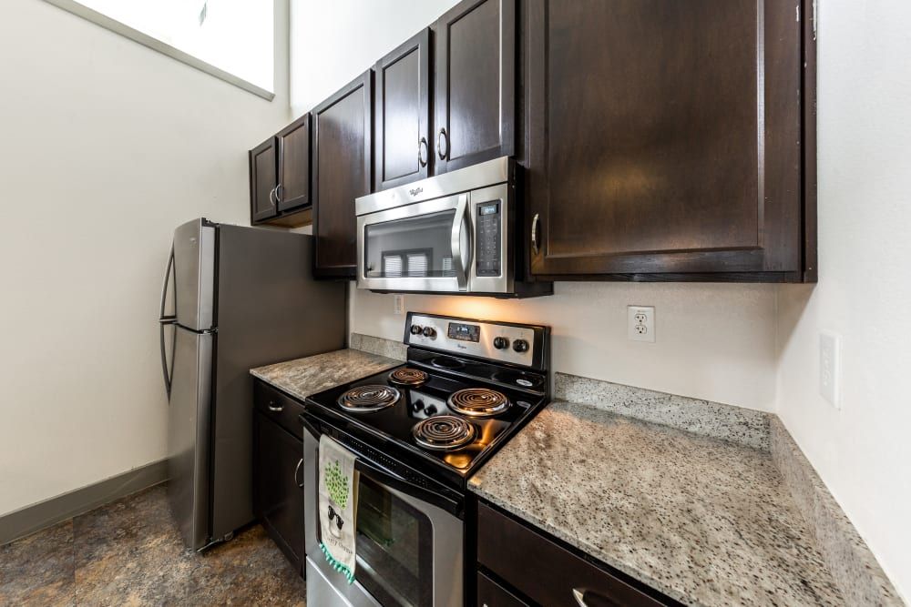 Student apartment kitchen with stainless steel appliances and granite counter tops at Regents West at 26th in Austin, TX, near UT Austin.