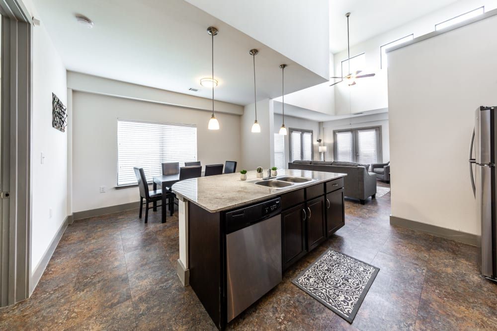 Student apartment kitchen with a large island and stainless steel appliances at Regents West at 26th in Austin, TX, near UT Austin.