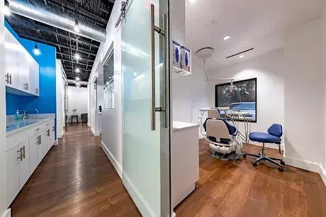 A dental office with a dental chair and a sink.