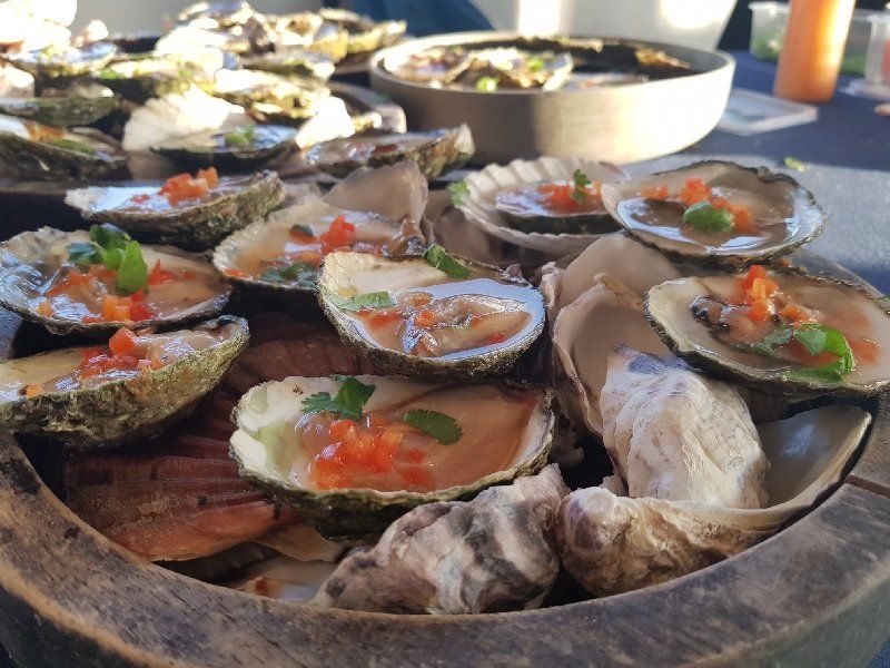 A wooden bowl filled with oysters and other seafood