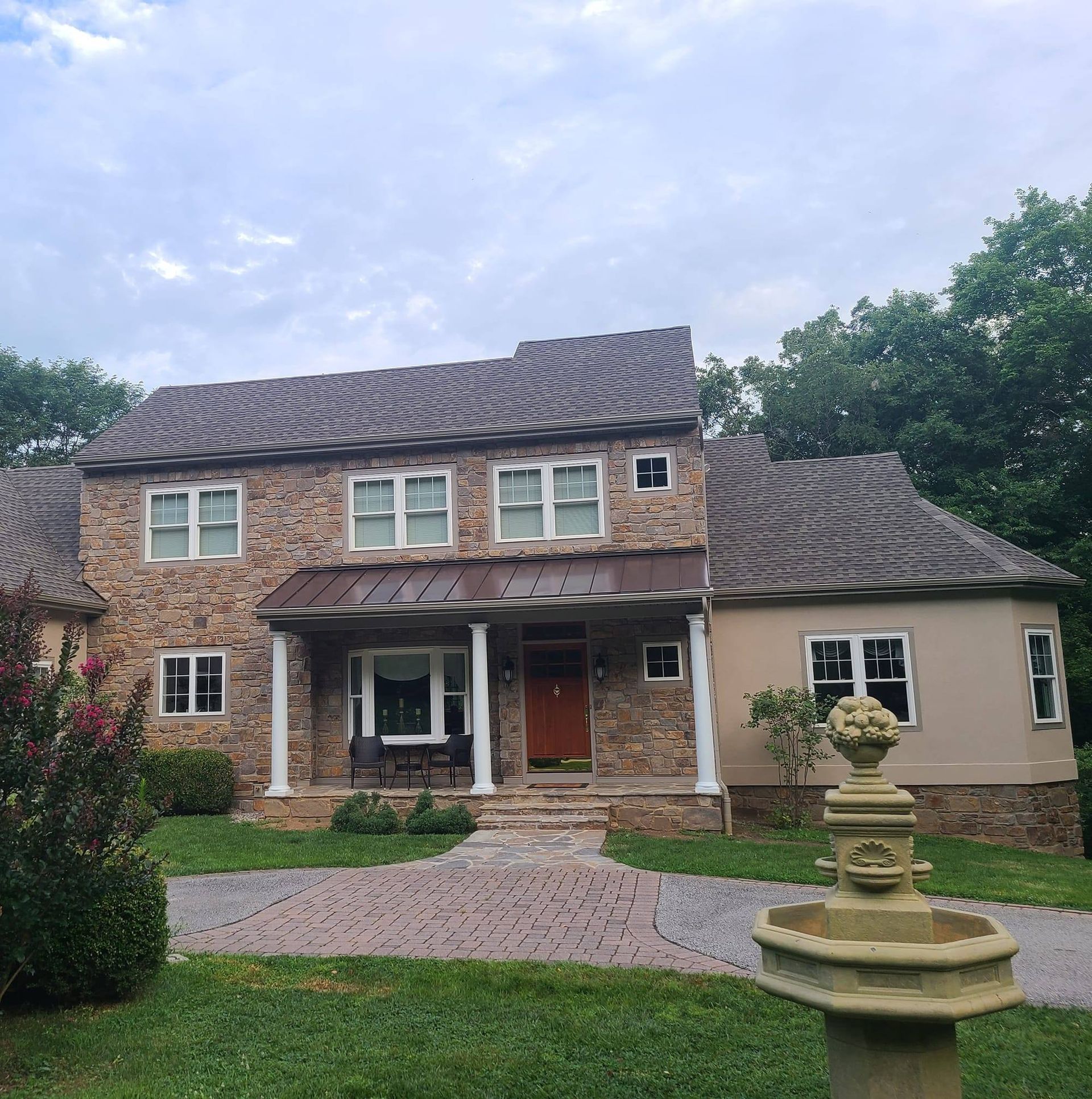 A large house with a fountain in front of it