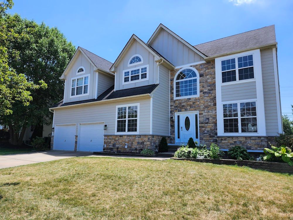 A large house with a lot of windows and a stone facade