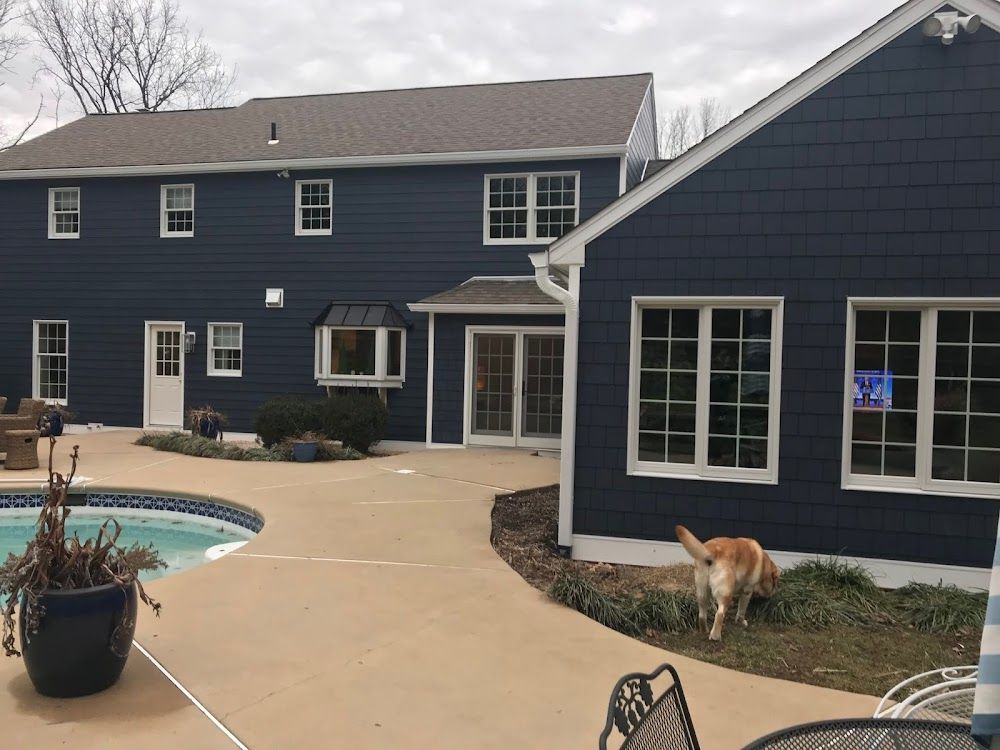 A large blue house with a swimming pool in the backyard