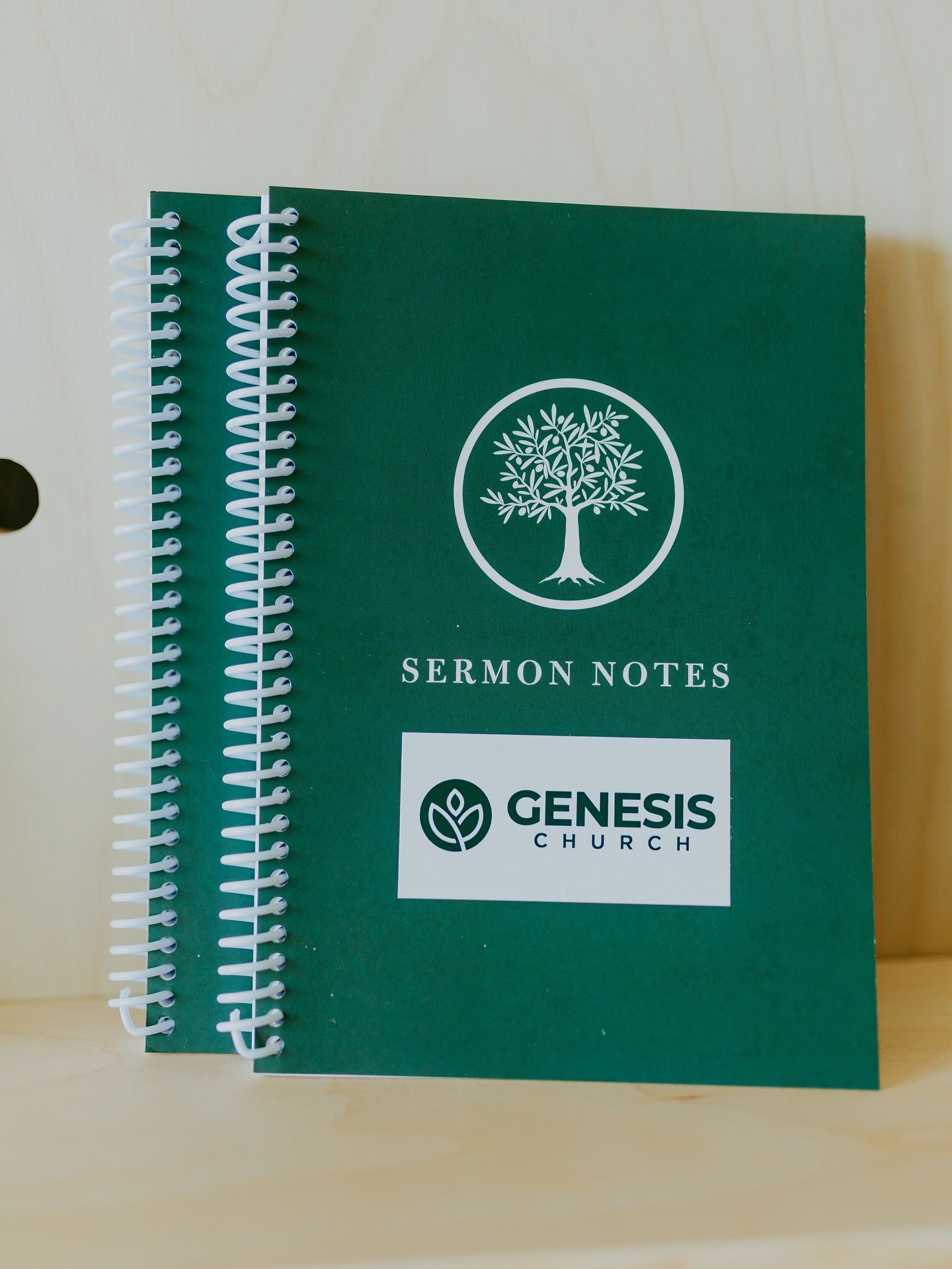 Two green spiral-bound notebooks labeled 