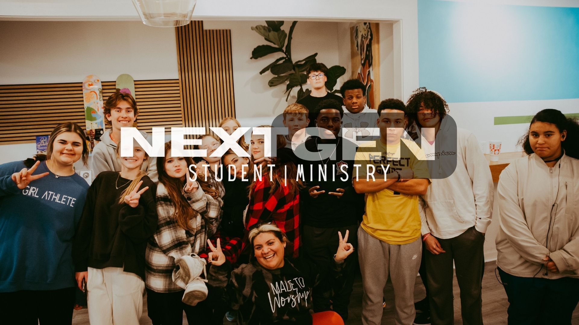 A group of young people are posing for a picture in a room.