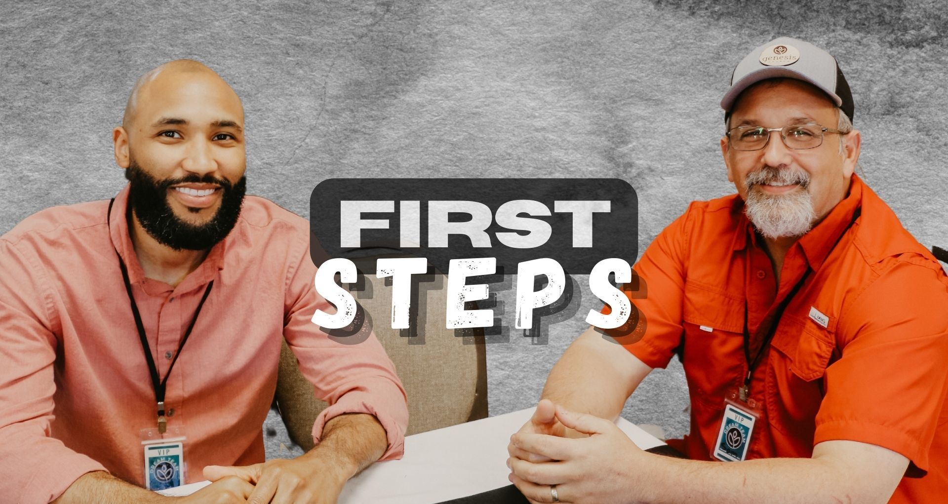 Two men are sitting at a table with the words `` first steps '' behind them.