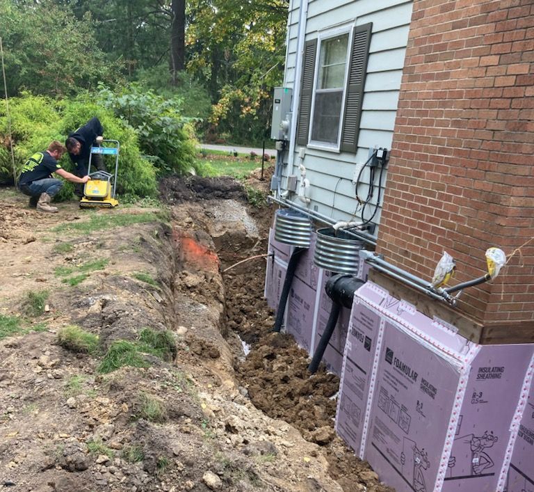 A man is working on the side of a brick house.