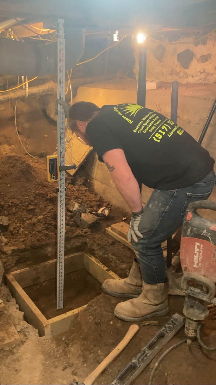 A man is digging a hole in the ground in a basement.