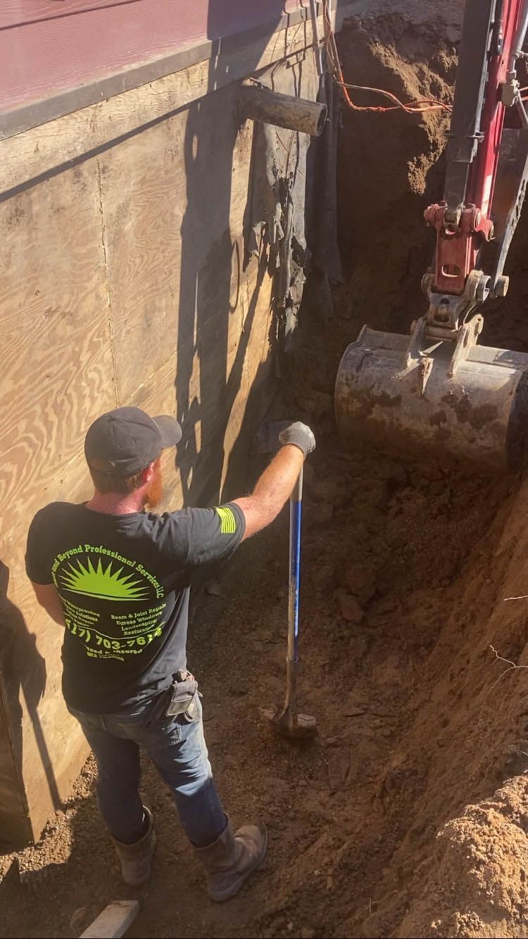 A man is digging a hole in the ground next to a building.