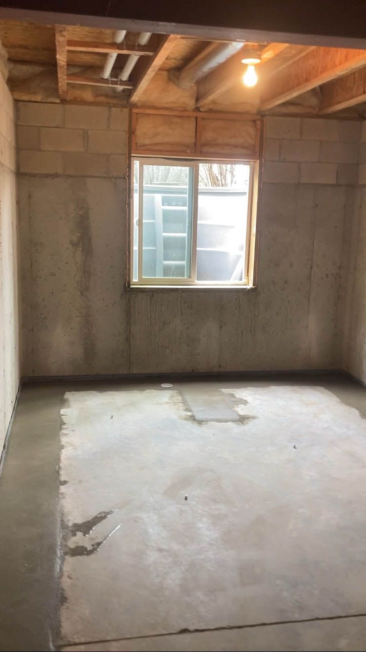 An empty room with a window and a light on the ceiling.