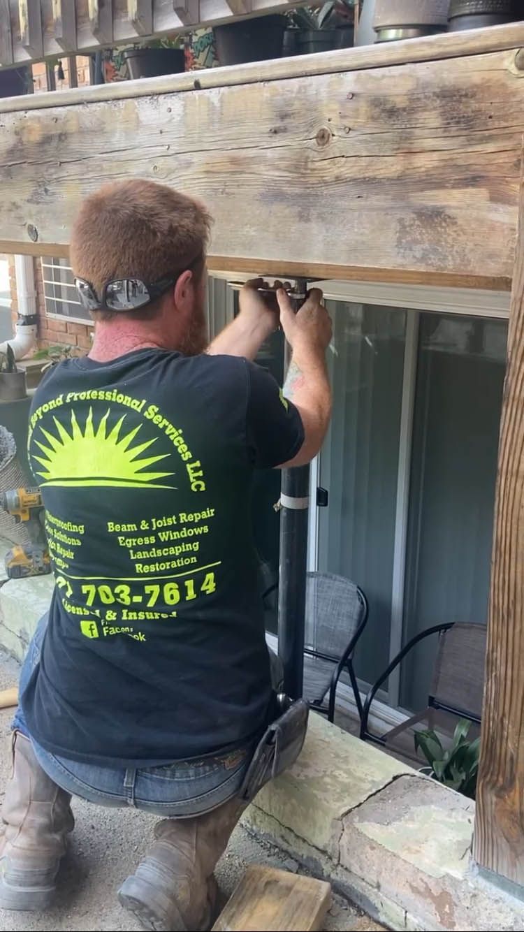 A man in a black shirt is working on a wooden deck.